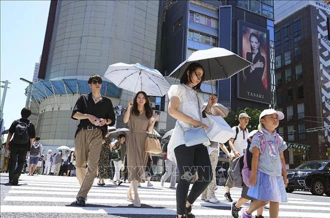 Người dân che ô tránh nắng nóng tại Tokyo, Nhật Bản, ngày 16/7/2024.