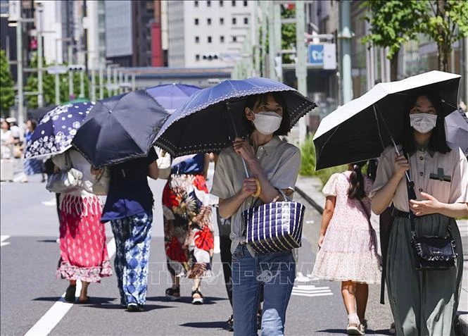Người dân di chuyển trên đường phố dưới trời nắng nóng tại Tokyo, Nhật Bản.