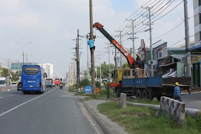 Công nhân di dời trụ điện trên Quốc lộ 13 phục vụ dự án Nâng cấp mở rộng đoạn qua TP Thuận An.