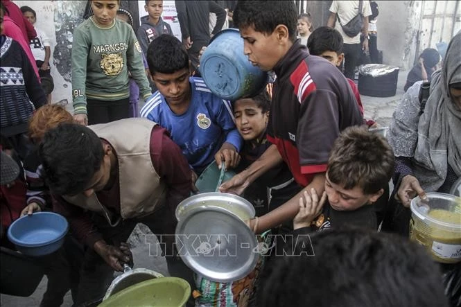 Người dân Palestine nhận thức ăn cứu trợ tại Dải Gaza ngày 23/10/2024.