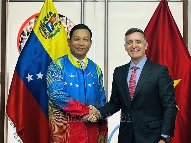 Đại sứ Vũ Trung Mỹ mặc áo đội tuyển Olympic quốc gia Venezuela do Bộ trưởng Franklin Cardillo trao tặng.