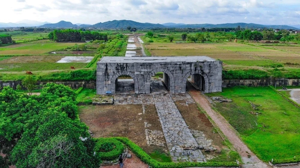 Cổng thành phía Nam Thành nhà Hồ với ba vòm đá lớn, bao quanh là cánh đồng lúa xanh mướt, tạo nên khung cảnh hùng vĩ và thanh bình. Ảnh: Trung tâm Bảo tồn Di sản Thành nhà Hồ cung cấp