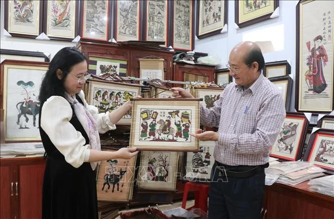 Nghệ nhân Nguyễn Hữu Hoa giới thiệu sản phẩm tranh mành dân gian Đông Hồ với du khách.