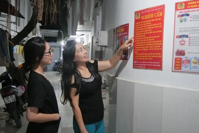 Chủ nhà trọ Lê Thị Kim Chi (phải) cập nhật các quy định an toàn cho công nhân.