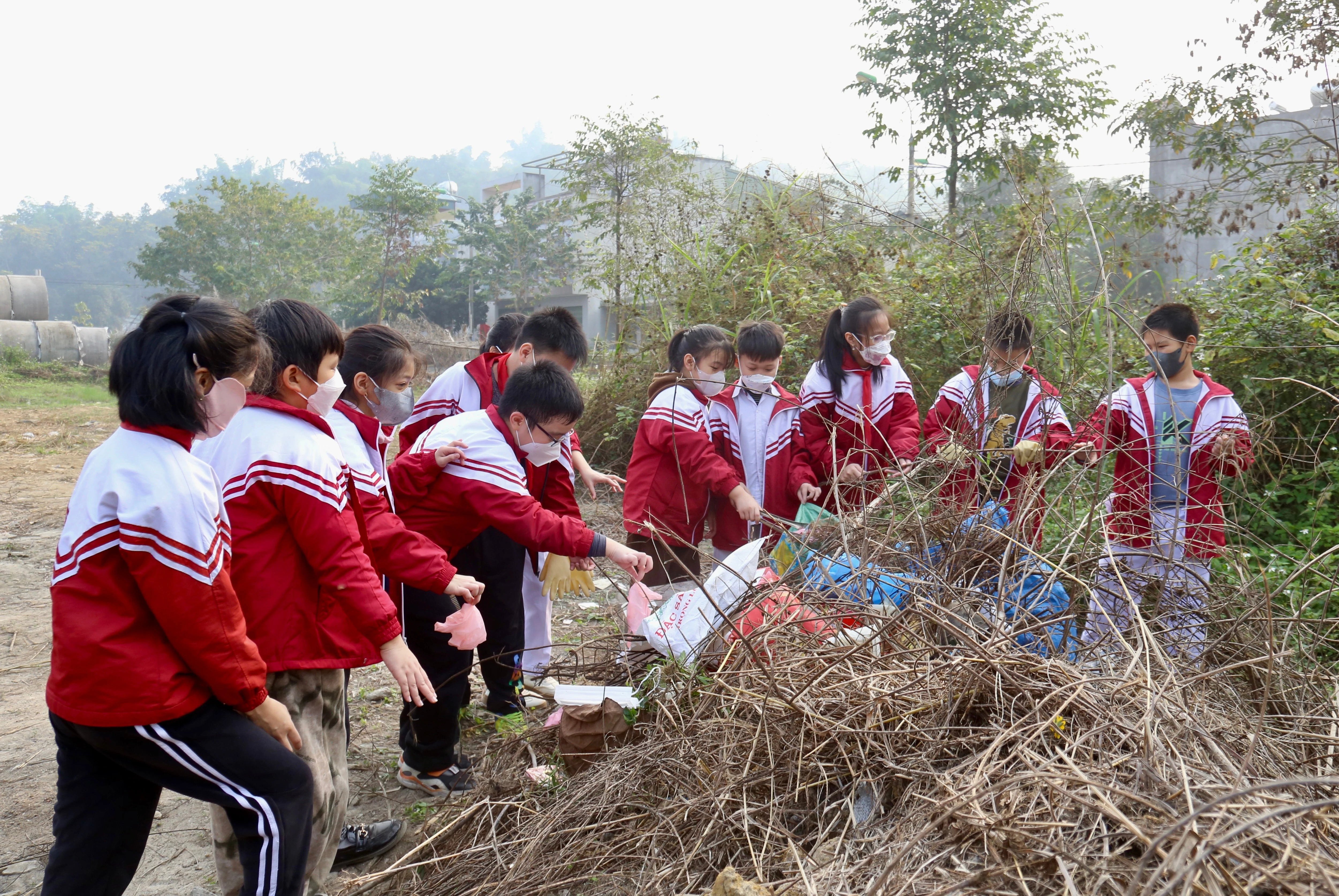 Học sinh tham gia dọn vệ sinh nơi công cộng.