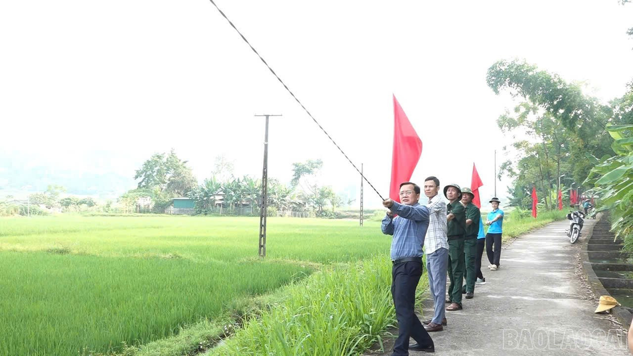 Đại diện các đơn vị và người dân đồng lòng kéo dây thực hiện công trình. baolaocai-br_cc.jpg