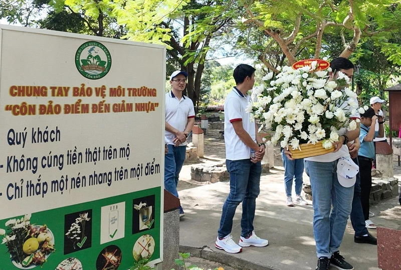 Một đoàn du khách vào viếng Nghĩa trang Hàng Dương trong buổi sáng 6/7 với Giỏ lễ xanh. (Ảnh: Mạnh Cường)