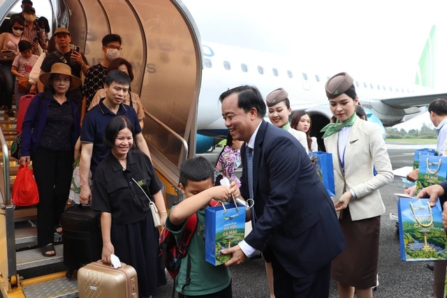 Bí thư Tỉnh ủy Cà Mau Nguyễn Tiến Hải và Chủ tịch UBND tỉnh Cà Mau Huỳnh Quốc Việt tặng quà chúc mừng các hành khách tham gia chuyến bay đầu tiên từ Hà Nội đến Cà Mau.