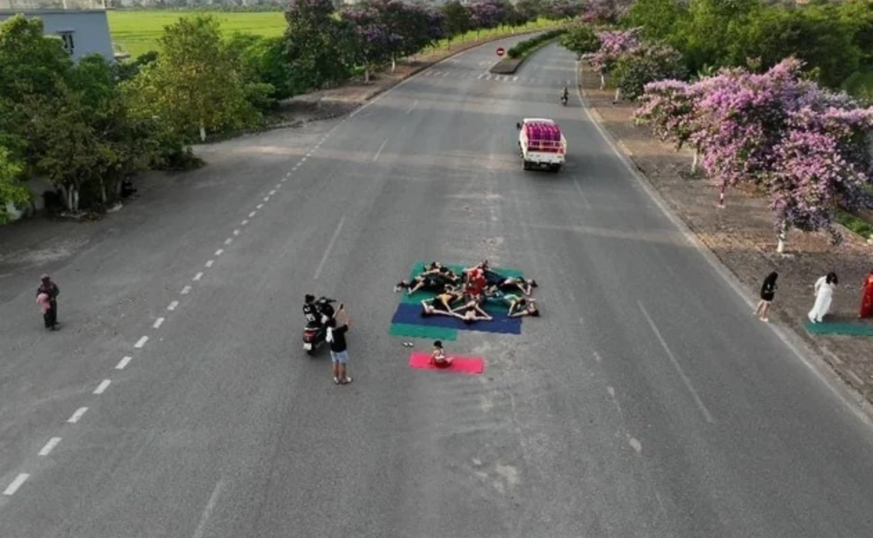 Nhóm phụ nữ đang nằm tập yoga ngay giữa đường nhánh QL37. Ảnh cắt từ Facebook