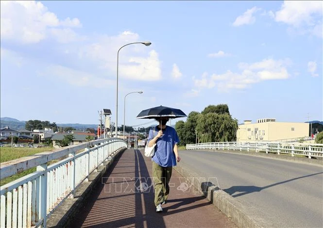 Người dân di chuyển dưới trời nắng nóng tại Fukushima, Nhật Bản.