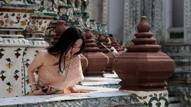 Một du khách mặc trang phục truyền thống của Thái Lan đến thăm chùa Wat Arun ở Bangkok. Ảnh: Reuters