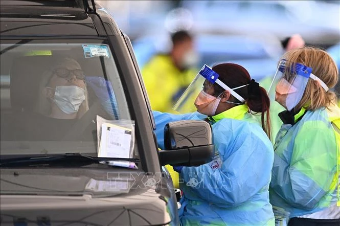 Nhân viên y tế lấy mẫu xét nghiệm COVID-19 cho người dân tại Sydney, Australia.