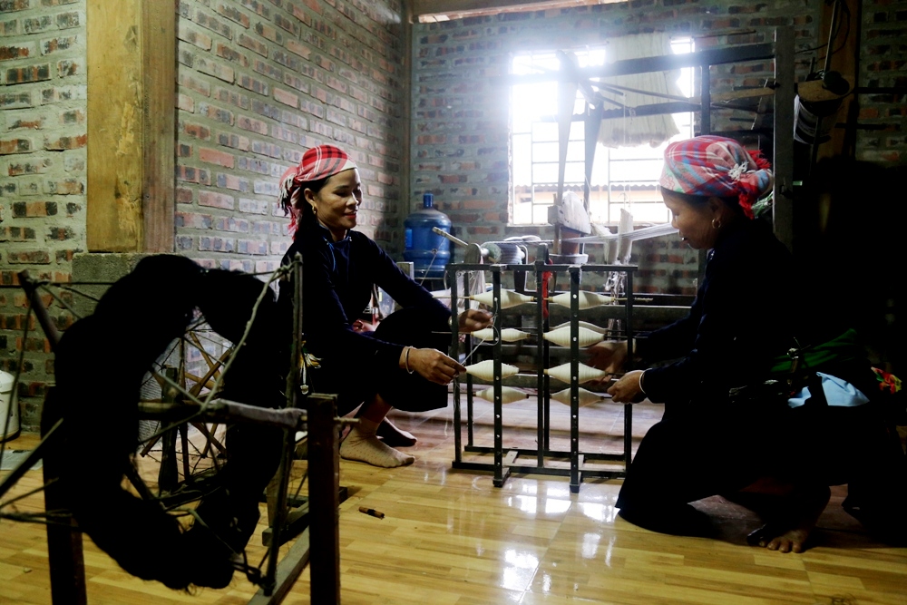 Phụ nữ Làng Giàng đang ngày đêm miệt mài dệt nên những tấm thổ cẩm truyền thống, không chỉ góp phần gìn giữ biểu tượng văn hóa cổ truyền của người Tày mà còn có ý nghĩa quan trọng trong chiến lược phát triển du lịch cộng đồng ở địa phương. Các sản phẩm thổ cẩm của người Tày rất đa dạng như: Chăn, đệm ngồi, gối, ga trải đệm, dây bao dao, địu… Dây bao dao từ xa xưa được coi là món quà quý, được nhiều cô gái gửi gắm tâm tình của mình dành tặng cho người con trai mà họ yêu mến. Dây được dệt có chiều dài khoảng 6m. Mỗi dây sẽ được các cô gái dệt trong khoảng một tuần. Những chiếc đệm ngồi được thêu bằng nhiều hoa văn bắt mắt. Thổ cẩm còn được dùng để trang trí gối. Các họa tiết trên gối được thêu tay tỉ mẩn bởi các hình ảnh gắn với đời sống của bà con như: Lá rau bợ, quạt cọ, hình con nhện, hoa bưởi, đôi chim hay cả thêu chữ. Để tạo ra những tấm vải thổ cẩm hay các tấm vải để thêu các họa tiết thổ cẩm phải trải qua nhiều công đoạn. Từ trồng bông, thu hái, tách bông khỏi hạt và sau đó là bật bông cho tơi Vê bông thành lọn tròn để mang đi kéo sợi. Bông sau khi kéo sợi được xe thành cuộn chỉ lồng vào khung kéo. Công cụ để dệt ra sản phẩm hoàn toàn bằng tre gỗ tự nhiên vô cùng thô sơ, do chính ngừơi dân tạo ra và không có bất kỳ chút công nghệ hiện đại nào. Sợi chỉ sẽ được các chị em cuốn quanh cột nhà để chuẩn bị xếp vào khung dệt. Những sợi chỉ được xếp vào khung cửi. Người phụ nữ Tày tranh thủ thời gian rảnh sẽ ngồi vào khung cửi để dệt. Từ đây những sản phẩm dệt thủ công đặc sắc được hình thành.