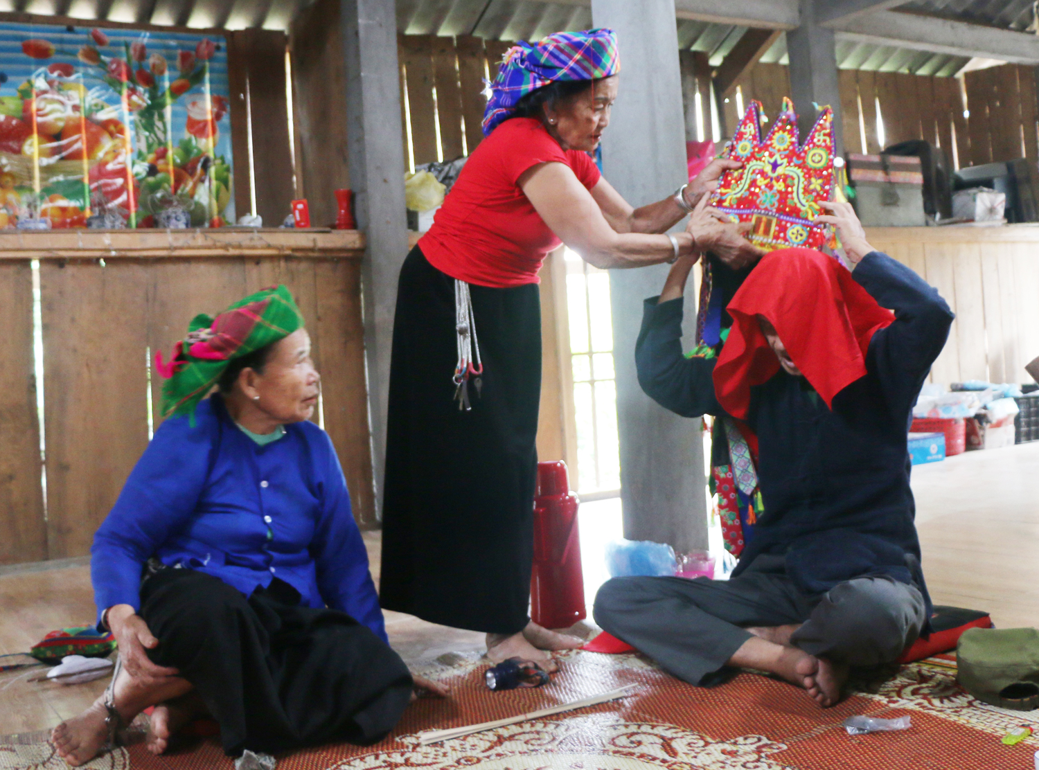 Bà Nguyễn Thị Na đội thử mũ cho thầy Then. Ảnh: TL