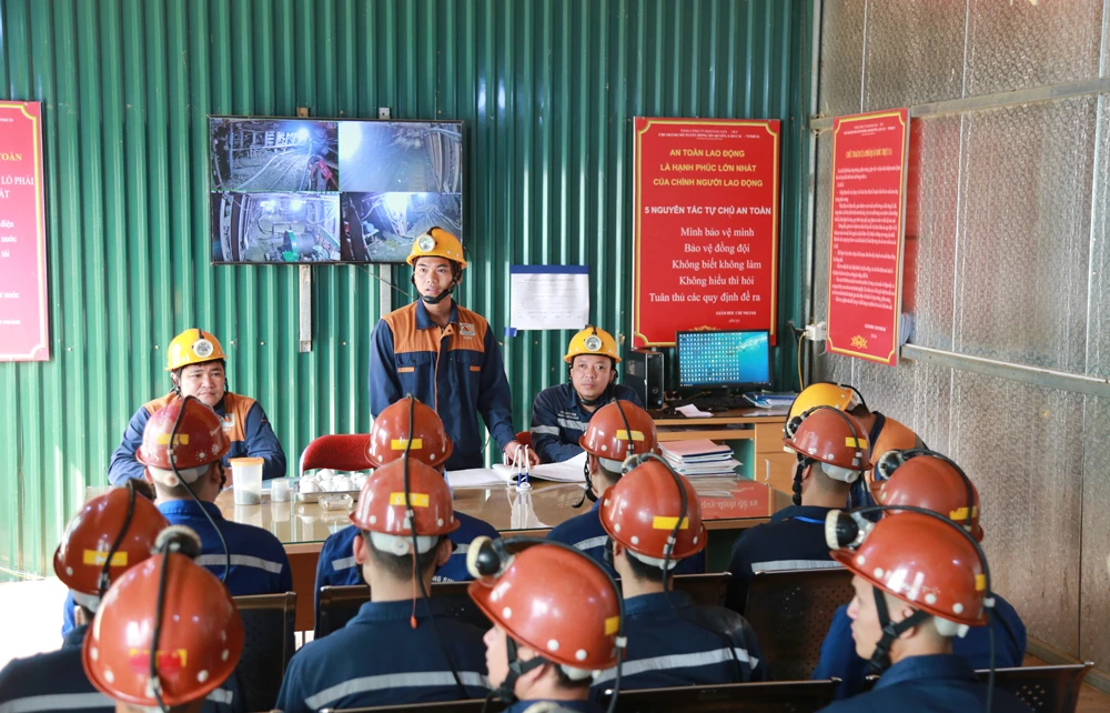 Trước mỗi giờ giao ca, các công nhân lại được phân công công việc và nhắc lại các quy trình, quy định an toàn. Từng tốp thợ tiến vào lò +150m (so với mức nước biển). Như một đoàn quân đi vào lòng đất. Những vỉa quặng nằm sâu trong lòng núi. Một gương lò chuẩn bị đưa vào khai thác. Máy xúc chuyên dụng múc từng gầu quặng quý giá ở vị trí cách cửa lò gần 3.000m, tại cao độ +30m (so với mức nước biển). Xe goòng được sử dụng để vận chuyển đá và quặng ra ngoài. Hệ thống thông gió hoạt động liên tục. Camera giám sát các vị trí trong hầm lò để đảm bảo an toàn tuyệt đối trong quá trình khai thác. Một tốp công nhân khác lại vào thay ca để tiếp tục guồng làm việc mới. Nhiều công nhân là người địa phương được tuyển dụng vào làm việc. Quản đốc Mạc Văn Tiến cho biết niềm vui lớn nhất của thợ mỏ là trở về nhà an toàn sau mỗi ca làm việc vất vả.