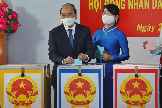 Chủ tịch nước Nguyễn Xuân Phúc cùng phu nhân thực hiện nghĩa vụ công dân của mình tại tổ bầu cử số 10, khu phố 7, thị trấn Củ Chi, TP. Hồ Chí Minh.