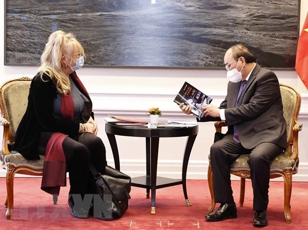 Chủ tịch nước Nguyễn Xuân Phúc đón nhận cuốn sách 'Hồ Chí Minh với những bức thư mong muốn hòa bình cho Việt Nam' được dịch sang tiếng Italy và phát hành tại Italy từ nguyên bản cùng tên bằng tiếng Việt với sự phối hợp biên tập của bà Sandra Scagliotti, nhà nghiên cứu về Việt Nam và ông Trần Doãn Trang, kiều bào tại Italy. (Ảnh: Thống Nhất/TTXVN)