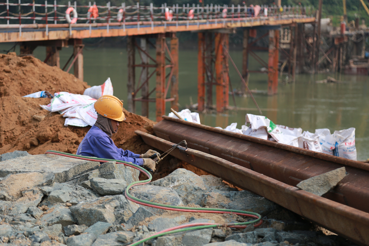 Để đảm bảo tiến độ, nhà thầu đã tổ chức công nhân thi công 3 ca liên tục. Nhiều công nhân ở ngoài tỉnh cũng đã sớm có mặt trên công trường. Trụ cầu T6 đang được tiến hành đổ bê tông bệ trụ. Cầu tạm được xây dựng phục vụ thi công trụ cầu T7 ở lòng sông. Thi công cọc khoan nhồi dưới nước tại trụ T7. Nhà thầu phấn đấu hoàn thành hạng mục này trước mùa mưa lũ. Một mũi thi công khác đang tiến hành thi công dầm cầu. Để đảm bảo phòng dịch, công nhân được chia thành từng nhóm nhỏ để thi công.
