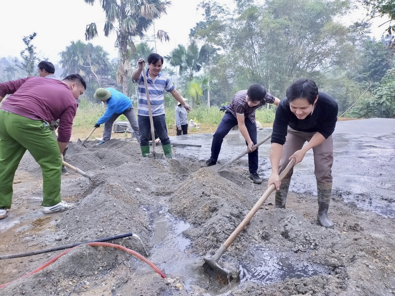 Cán bộ, công chức xã giúp thôn Pịt đổ bê tông khu sân đền.