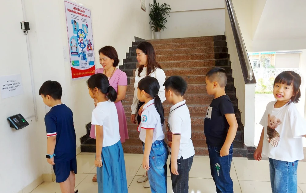 Học sinh Trường Tiểu học Nguyễn Du điểm danh bằng máy tự động khi đến lớp học.