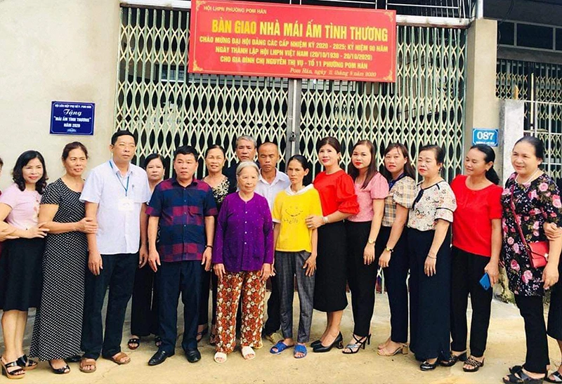 Các đại biểu chụp ảnh lưu niệm với gia đình bà Vụ sau khi bàn giao nhà.