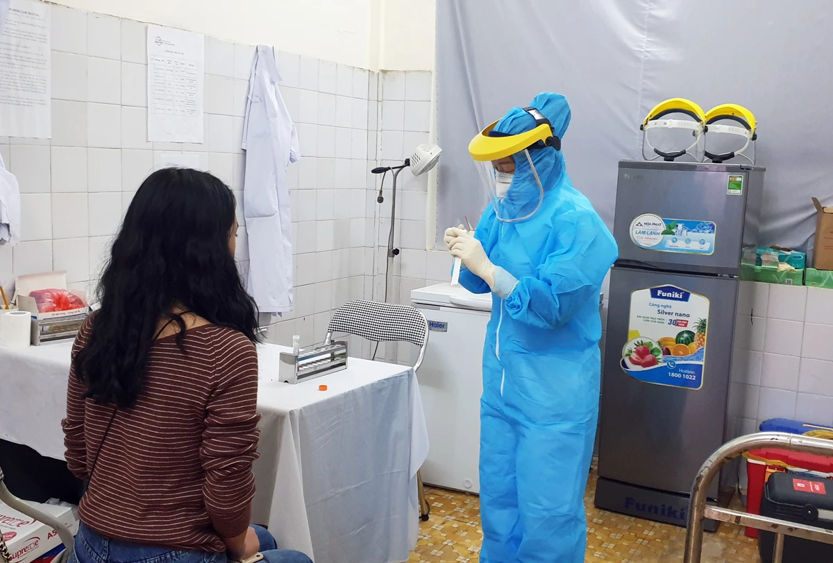 Bác sỹ Trung tâm Y tế thành phố Lào Cai lấy mẫu xét nghiệm SARS-CoV-2 cho người về từ vùng dịch (Ảnh chụp ngày 4/2/2021).