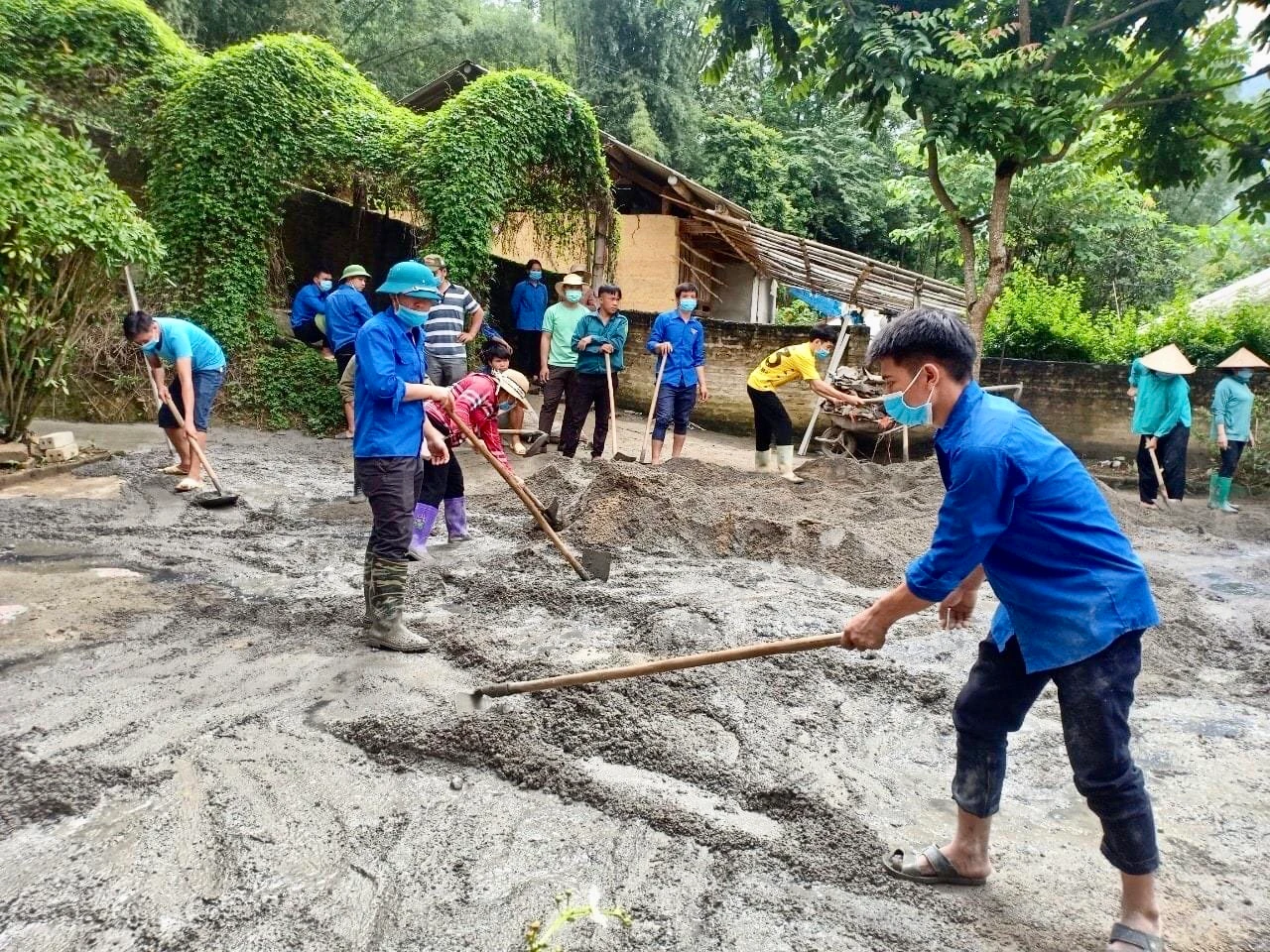 Các lực lượng tình nguyện tham gia đổ bê tông sân trường.