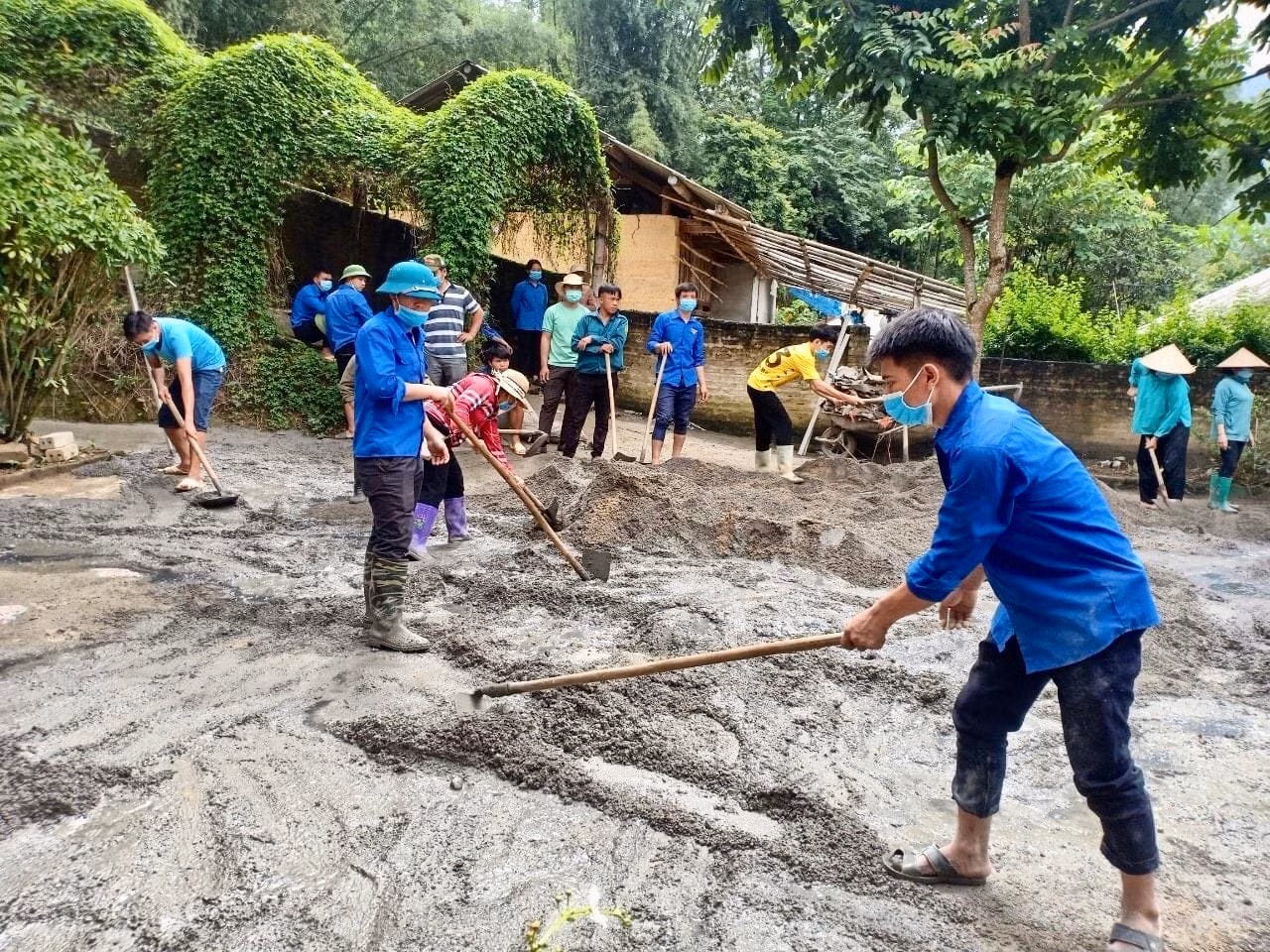 Các lực lượng tình nguyện tham gia đổ bê tông sân trường.