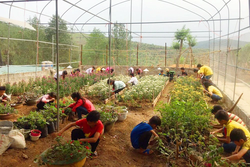 Học sinh Trường Tiểu học và THCS Cốc Mỳ chăm sóc vườn hoa làm đẹp cho trường.