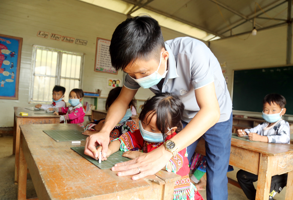 Thầy giáo Nguyễn Ngọc Quân dạy học sinh lớp 1 những nét chữ đầu tiên.