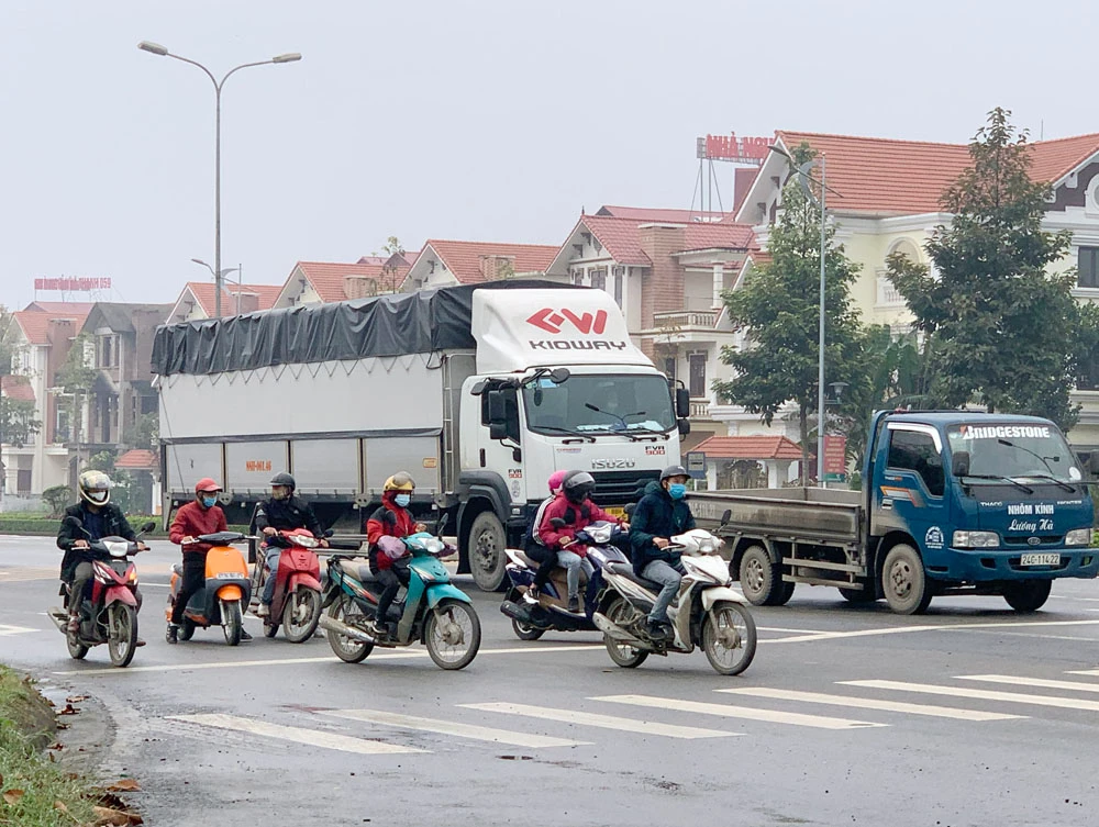 Người dân tham gia giao thông trên đường Trần Hưng Đạo nghiêm túc thực hiện quy định đeo khẩu trang.