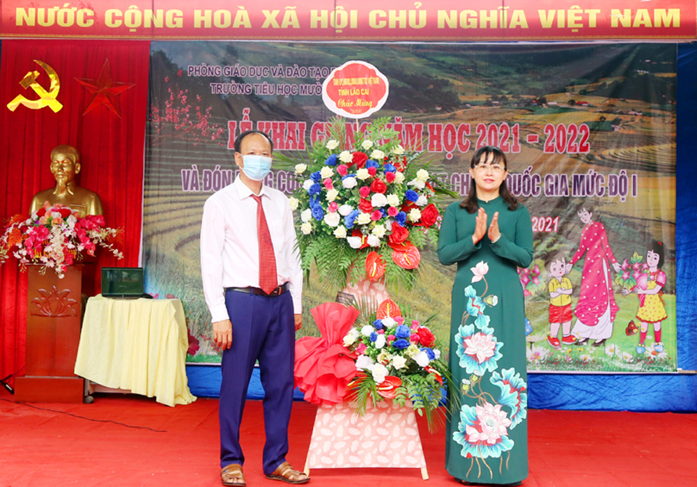 Phó Chủ tịch UBND tỉnh Giàng Thị Dung tặng hoa Trường Tiểu học Mường Vi nhân ngày khai giảng năm học mới.