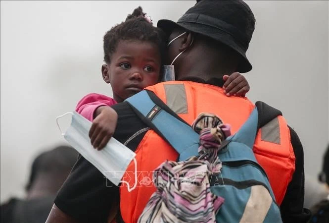 Người di cư mang theo con nhỏ được chuyển từ làng Bajo Chiquito tới trạm tiếp nhận ở Lajas Blancas, tỉnh Darien, Panama ngày 31/8. Ảnh: AFP/TTXVN.