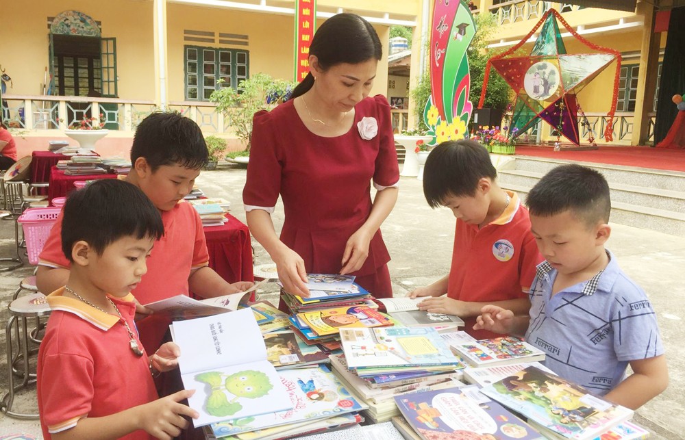 Các giáo viên giúp các em lựa chọn sách.