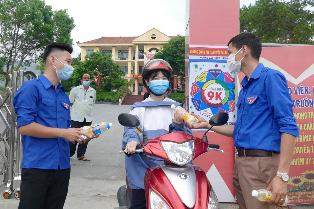 Thanh niên tình nguyện chúc mừng thí sinh đầu tiên hoàn thành môn thi Ngữ văn tại điểm thi Trường THPT Chuyên Lào Cai.