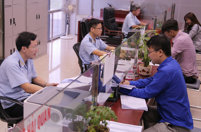 Cán bộ hải quan hướng dẫn doanh nghiệp làm thủ tục thông quan.