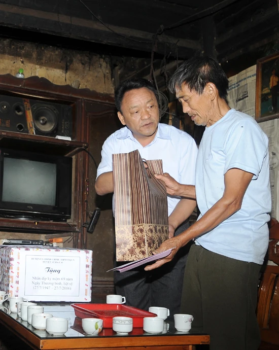 Đồng chí Giàng Mạnh Nhà tặng quà thương binh Thào Dìn Sẩu (xã Thào Chư Phìn).