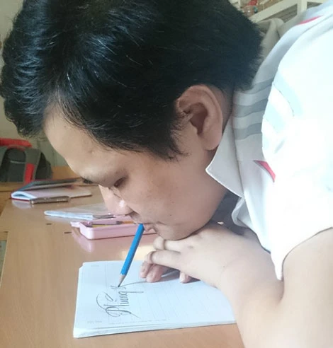 Bằng sự khổ luyện, thầy Trường có thể viết chữ rất đẹp bằng miệng.