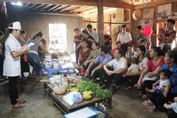 Cán bộ y tế hướng dẫn người dân cách chăm sóc, chế độ dinh dưỡng cho bà mẹ và trẻ em.