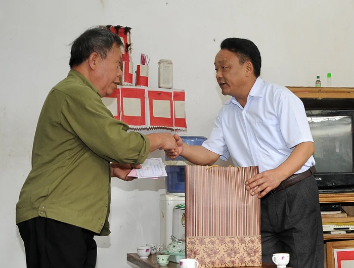 Đồng chí Giàng Mạnh Nhà tặng quà thương binh Giàng Seo Phình (xã Si Ma Cai).