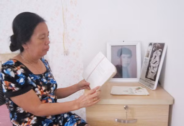 Bà Phan Kim Lương đang xem lại những kỷ vật của chồng.