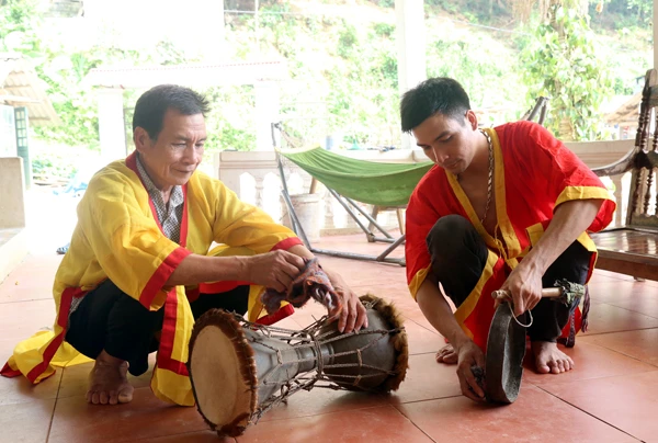 Nghệ nhân Bàn Văn Sang chuẩn bị nhạc cụ biểu diễn múa trống đất.