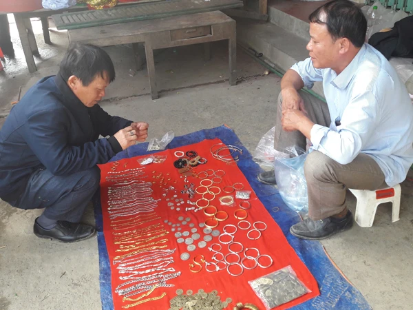 Người dân tìm hiểu những đồng xu bày bán tại chợ Mường Khương.