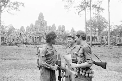Một người lính Campuchia (trái) và hai chiến sĩ quân tình nguyện Việt Nam bên ngoài đền Angkor Wat năm 1982.