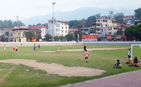 Nhiều người phải ngồi ngoài sân chờ đến lượt để được vào đá bóng.