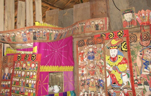 Trang trí cắt dán hoa văn hình mặt trời ở bàn thờ của trưởng tộc.