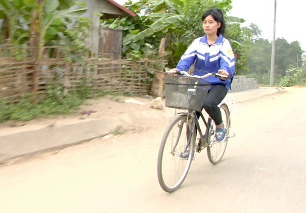 Mã Thị Trang và chiếc xe đạp được mượn - “người bạn” đồng hành đến trường của em.