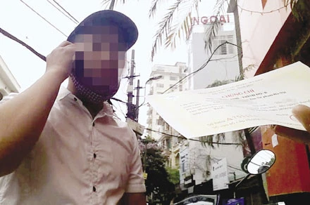 Một đối tượng “cò” đang chuyển giao chứng chỉ ngoại ngữ giả cho khách hàng.