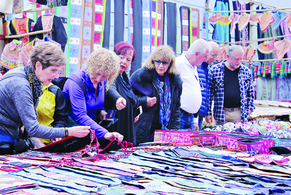 Du khách chọn mua thổ cẩm tại chợ phiên Bắc Hà.