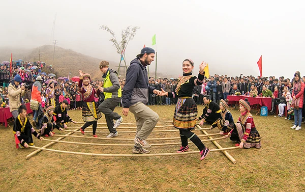 Khách du lịch vui cùng dân bản trong một lễ hội tại Sa Pa.